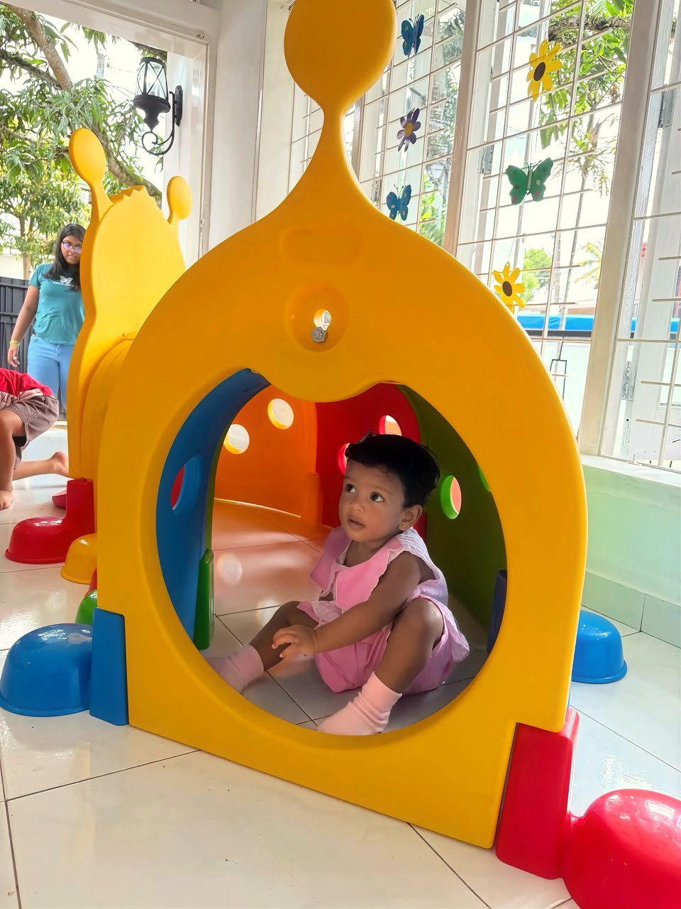 A child exploring the play house at Little Blessings